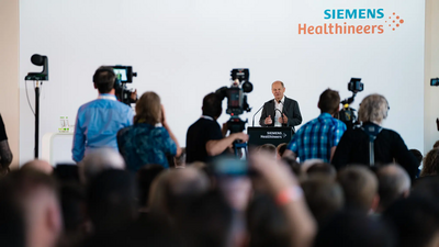 Olaf Scholz spricht auf vor Mitarbeitenden von Siemens Healthineers und Presseleuten